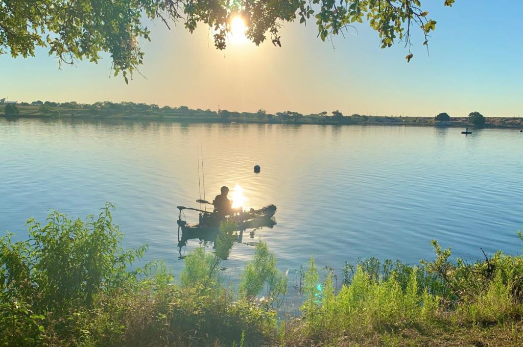 Golden hour at Marine Creek Lake near Azle, highlighting the popular 6-mile loop trail and waterfront activities for weekend travelers.