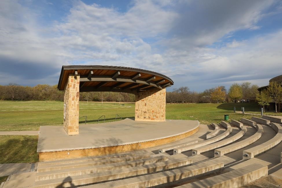 Scenic view of the open-air amphitheater at Azle Central Park, highlighting the green space and outdoor adventure facilities available to weekend visitors.